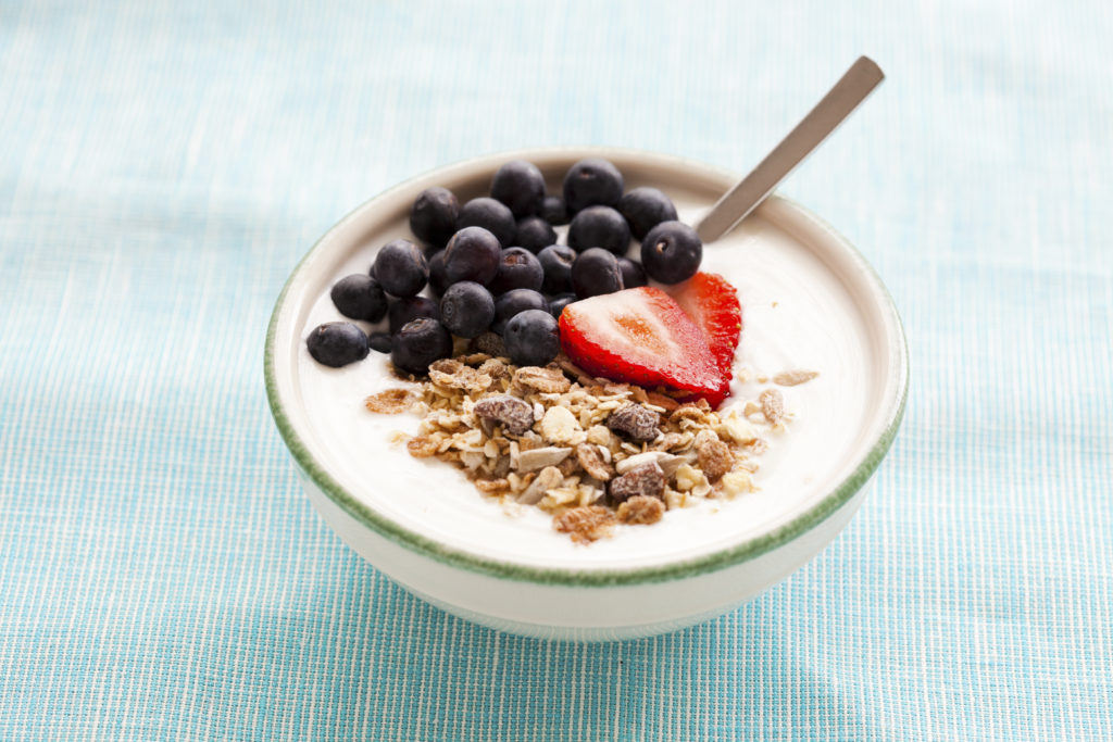 Bowl of muesli with yoghurt, strawberries and blueberries for healthy breakfast